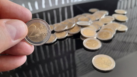 2 euro coins in the hands of a man