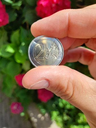 Female hand holding a coin.
