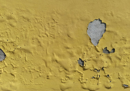 Rising damp on a yellow plastered wall - damaged