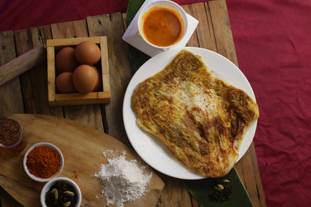 prata canai style pancake with egg and curry on wood background.の写真素材