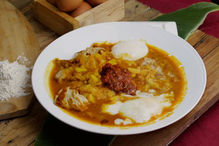 prata canai style  dhall curry spicy curry with egg in white plate on wooden table. malaysia food breakfast choiceの写真素材