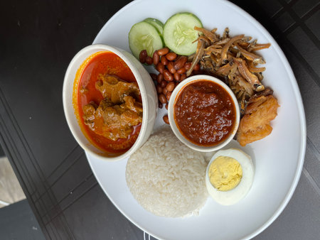 Balanced Beef Curry Plate With Rice, Sambal, Egg, Peanuts, And Vegetablesの写真素材