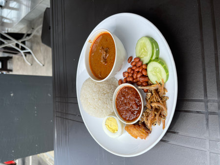 Balanced Beef Curry Plate With Rice, Sambal, Egg, Peanuts, And Vegetablesの写真素材