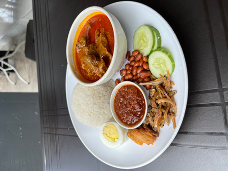 Balanced Beef Curry Plate With Rice, Sambal, Egg, Peanuts, And Vegetablesの写真素材