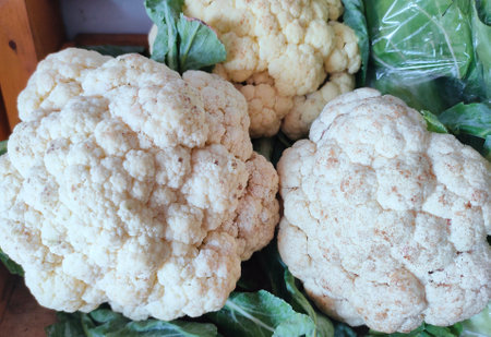 Close up on a head of white cauliflower on display for sale at Farmer's Market.の写真素材