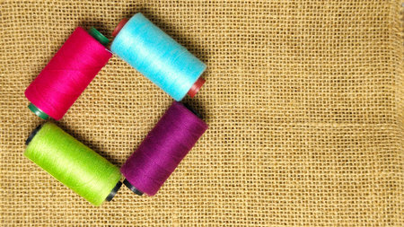 colorful threads placed on top of burlap