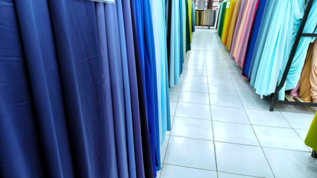 Fabrics of different blue shades neatly arranged in a retail store.の写真素材