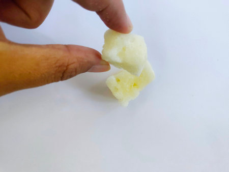 Hand holding two sugar cubes