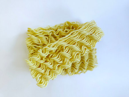 Close up of raw instant noodles on a white surface.の写真素材