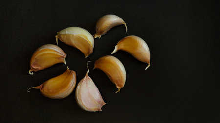 Close-up of garlic cloves on a dark surfaceの写真素材