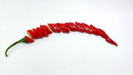 Big Red Chili Pepper Slices on a white background. Chili (Capsicum annum L.) is a widely cultivated vegetable commodity. Suitable for culinary and agricultural conceptsの写真素材