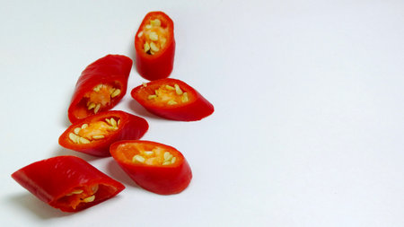 Big Red Chili Pepper Slices on a white background. Chili (Capsicum annum L.) is a widely cultivated vegetable commodity. Suitable for culinary and agricultural conceptsの写真素材