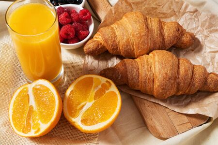 Breakfast served with croissants, coffee, orange juice and berries.の写真素材