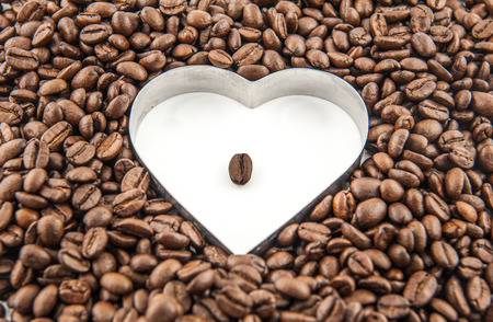 Coffee beans in the white heart surrounded by coffee beans の写真素材