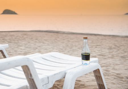 Water bottle on a beach chair by the oceanの写真素材