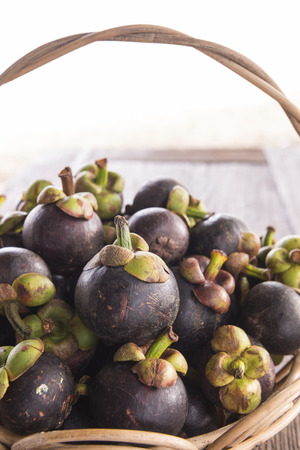 Thailand Mangosteen fruit basket placed on the wooden floor.の写真素材