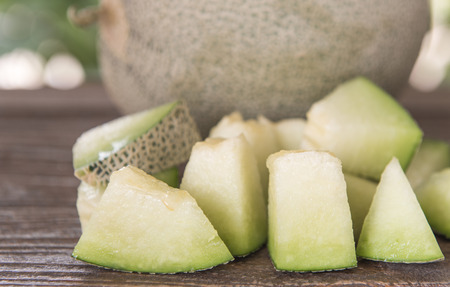 Full and sliced ââcantaloupe melon on wooden floor.の写真素材