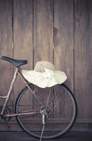 Old bicycle with hat on wooden wall.の写真素材