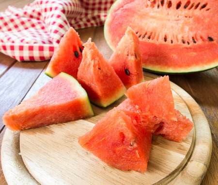 Sliced ââwatermelon pieces on a wooden tray.の写真素材