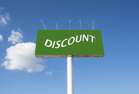 Signs advertising discount green against a backdrop of crystal-clear sky.の写真素材