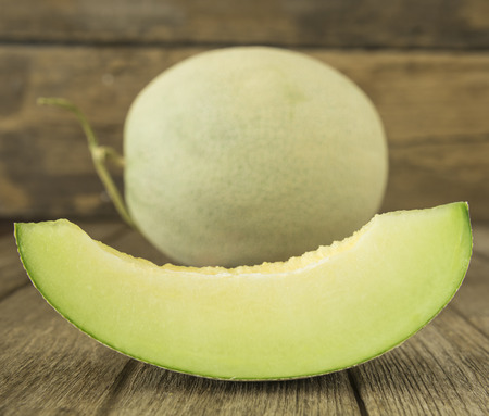 Fresh sliced melon pieces in wood plate.の写真素材