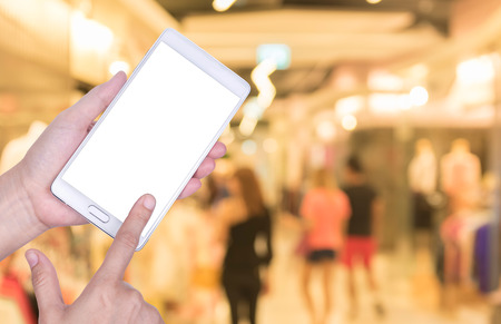Human hand hold and touch screen smart phone, tablet,cellphone on blurred Shopping mall background.の写真素材