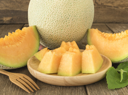 Fresh sliced melon pieces in wood plate.の写真素材
