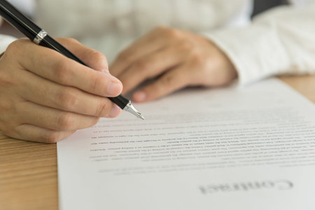 closeup pen in hand's  businessman preparing to sign an important document.の写真素材