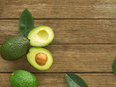 avocado and Sliced avocado slices on a dark wood background.