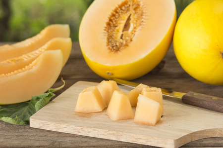 Fresh yellow sliced melon ( Canary melon or winter melon) pieces in wood plate; Selected focus.の写真素材