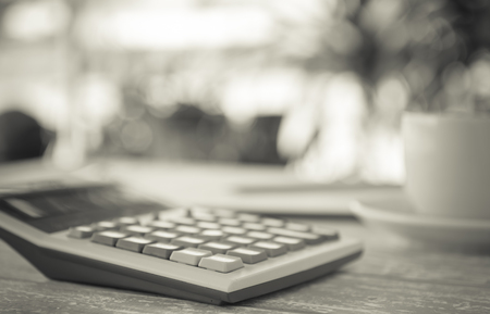 Calculator placed on a workdesk against a backdrop bokeh nature; Business concept, selected focusの写真素材