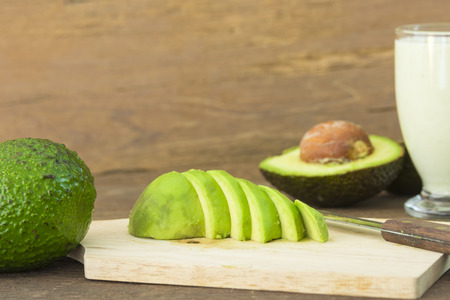 avocado and Sliced avocado slices on wooden board.の写真素材