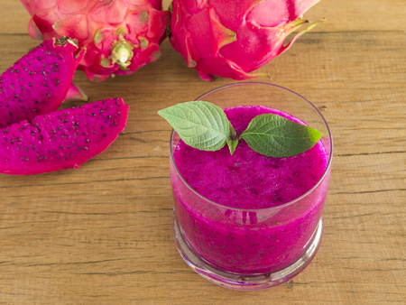 fresh red dragon fruit juice and sliced  on wood background.の写真素材