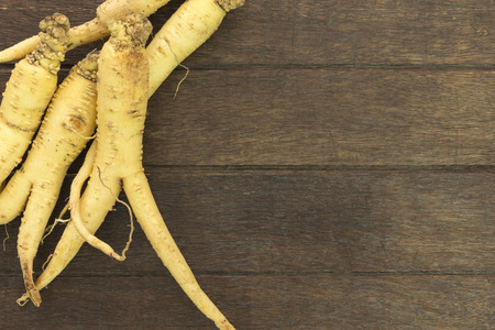 Ginseng root is placed on the wooden floor; Herbal Health Care.の写真素材