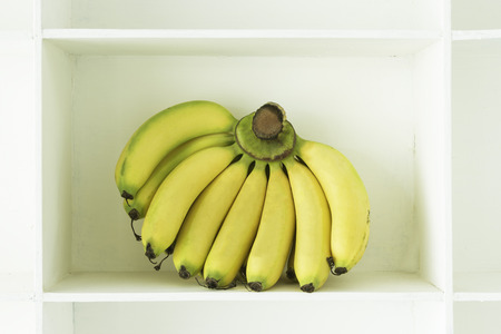 Bunch of bananas on the shelves of white.の写真素材