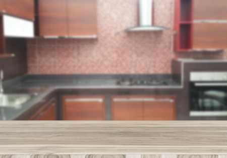 Wood table top on blur the background of the kitchen. - can be used for display your products or promotional and advertising postersの写真素材