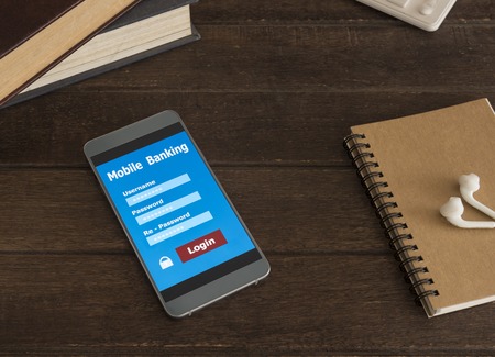 mobile smart phone Placed on a wooden table with mobile banking application.の写真素材