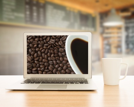labtop and cup of coffee on table in cafe.の写真素材