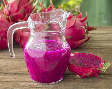 fresh red dragon fruit juice and sliced  on wood background.の写真素材