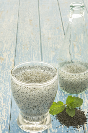 Sweet basil seed drink in glass of water on woodden background.の写真素材