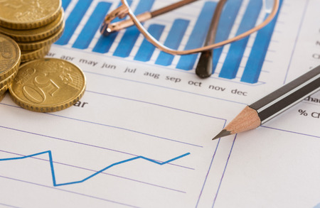 Closeup pen on financial graph report with money on desk's manager. concept of finance background, finances, finance business.の写真素材