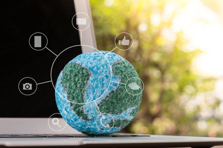 mock-up the globe with digital social media network on keyboard laptop computer in nature background