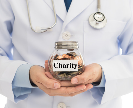 Doctors hold money jar. Concept of Charity , Donate for  procurement of medical equipment and help poor patientsの写真素材