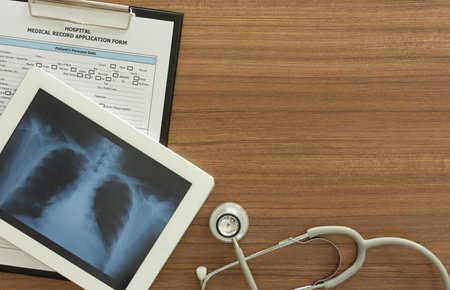 x-ray lung image in tablet computer, stethoscope, medical document form on desk of doctor...