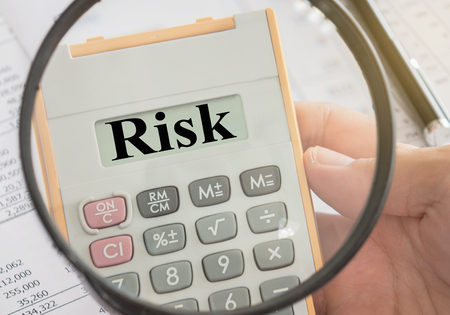 Risk word in calculator and magnifier. concepts of risk management, risk assessment.の写真素材