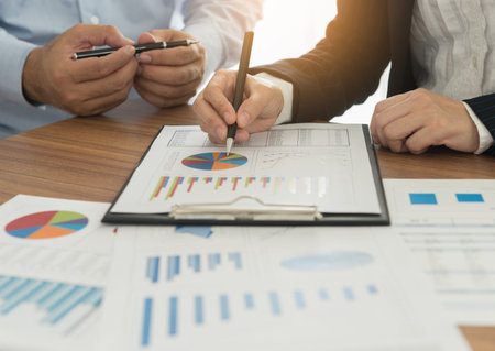 Financial advisor team are analyzing return on investment from business charts report.  Concept of...