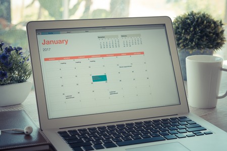 Schedule Planning laptop on the calendar as reminders of important dates or to schedule a meeting or event reminders concept. Vintage Style.の写真素材