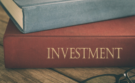 Investment and finance Concept. Books on finance and the growth investment analysis report on desk of investor.の写真素材