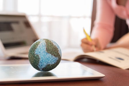 Mock up the globe with digital social media network on notebook with working women at office. Concept of Connection, Communication, Technology, Business and Financial Online.の写真素材