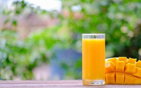 Fresh mango juice and mango fruit with a natural backdrop.の写真素材